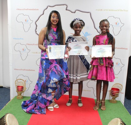 Three children on stage holding their certificates at the 2022 African Children of the Year awards.